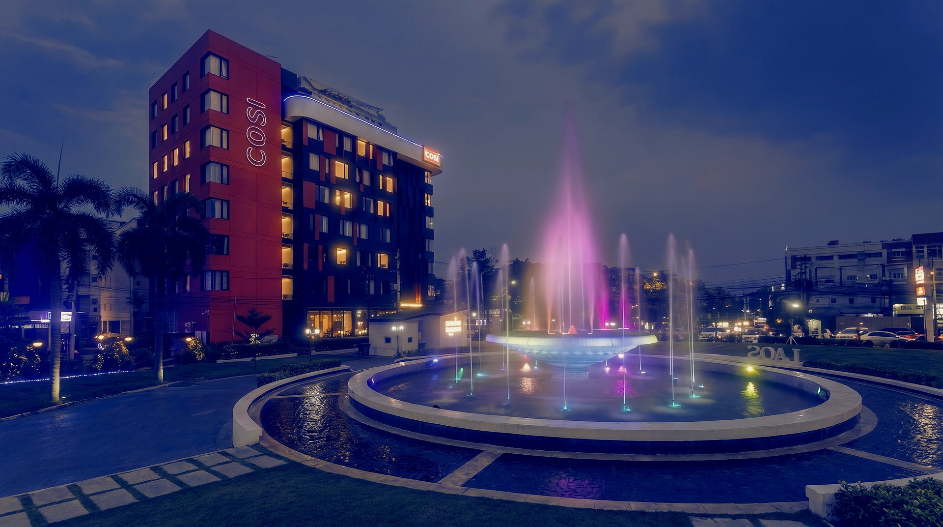 Cosi Nam Phu Hotel glowing warmly at dusk in Vientiane